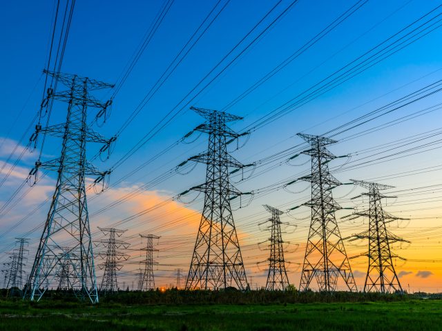 High voltage power tower industrial landscape at sunrise,urban power transmission lines.